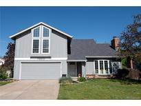 Charming two-story home featuring a gray exterior, attached garage, and well-manicured front lawn at 7600 S Ulster Ct, Centennial, CO 80112