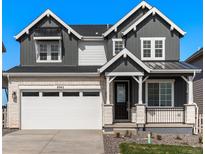 Two-story house with gray siding, white trim, and a two-car garage at 8942 Whiteclover St, Littleton, CO 80125