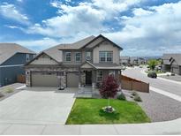 Charming two-story home featuring a well-manicured lawn, two car garage, and a welcoming front porch at 1624 Pinion Wing Cir, Castle Rock, CO 80108