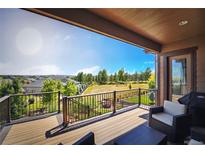 Relaxing back deck area with grill, chair, and outdoor views of the yard and neighborhood at 26642 E Peakview Pl, Aurora, CO 80016
