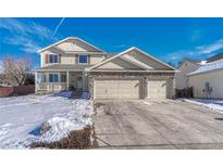 Two-story house with a three-car garage and snow-covered front yard at 11299 Glenmoor Cir, Parker, CO 80138