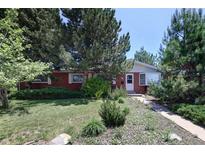 Charming brick home with a lush front lawn, mature trees, and a welcoming walkway at 2900 S Golden Way, Denver, CO 80227