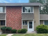 Charming brick and siding townhouse with a well-maintained lawn and mature shrubs at 2218 Coronado N Pkwy # B, Denver, CO 80229