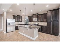 Spacious kitchen features granite countertops, stainless steel appliances, and dark wood cabinets at 5521 Ensenada St, Denver, CO 80249