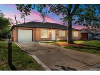 Charming brick home featuring a well-maintained lawn and an attached garage with a concrete driveway at 1269 N Revere St, Aurora, CO 80011