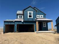 Two-story home exterior showing an attached two-car garage and a covered entryway in mid-construction at 39715 Gibson St, Elizabeth, CO 80107