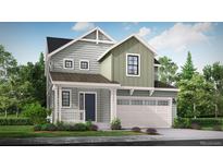 Charming two-story home featuring light green siding, a covered porch, and a two car garage at 39715 Gibson St, Elizabeth, CO 80107