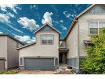 Charming townhouse with a two-car garage, brick driveway, and beautifully landscaped entrance at 9723 Bennett Peak St, Littleton, CO 80125