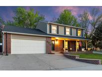 Charming two-story home with brick and siding exterior, covered porch, and well-maintained lawn at 504 E Otero Ct, Littleton, CO 80122