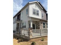 Beautiful two-story home with stone accents, neutral siding, and a charming front porch at 1988 S Haleyville Way, Aurora, CO 80018