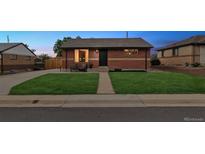 Charming brick home with a well-manicured lawn and inviting front porch seating area at 7833 Raritan St, Denver, CO 80221