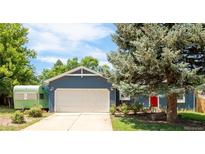 Charming blue home with a two-car garage, mature trees, and a red front door at 12175 Birch St, Thornton, CO 80241