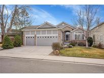 Charming gray home with a well-manicured lawn and a three-car garage at 13649 Plaster Cir, Broomfield, CO 80023