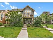 Inviting two-story home with a well-manicured lawn and charming balcony at 8260 E 24Th Dr, Denver, CO 80238