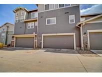 Attached garages on gray townhomes feature individual driveways and modern architecture at 1552 Venice Ln, Longmont, CO 80503