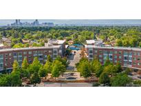 Panoramic aerial view of Central Park neighborhood with buildings, lush trees, and the Denver skyline in the distance at 7700 E 29 Ave # 304, Denver, CO 80238