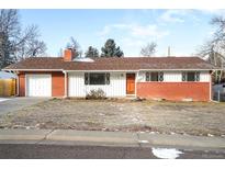 Ranch style home with brick facade, attached garage, and landscaping at 1065 Youngfield St, Golden, CO 80401