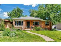 Charming brick home featuring a well-manicured lawn, front porch, and beautiful landscaping at 2240 S Clermont St, Denver, CO 80222