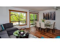 Bright living room featuring hardwood floors, neutral walls, and views of mature trees at 827 Maxwell Ave # H, Boulder, CO 80304
