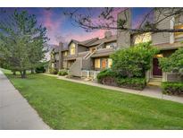 Charming townhouse complex showcasing landscaped front lawns and inviting entrances under a colorful twilight sky at 1099 S Walden Way # 205, Aurora, CO 80017