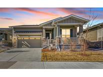 Charming single-Gathering home featuring stone accents, a covered porch, and a well-maintained front yard at 8501 S Rome Way, Aurora, CO 80016