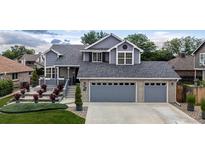 Charming two-story home featuring a well-manicured front yard and an attached two-car garage at 6888 Howell St, Arvada, CO 80004