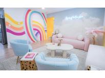 Vibrant living room featuring colorful rainbow wall art, modern furniture, and stylish decor at 7799 Pecos St, Denver, CO 80221