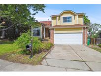 Charming two-story home with a well-manicured lawn, attached garage, and appealing brick accents at 10525 Hobbit Ln, Westminster, CO 80031