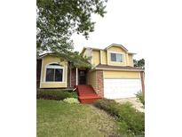 Inviting two-story home with a well-maintained front yard, attached two-car garage, and charming red brick accents at 10525 Hobbit Ln, Westminster, CO 80031