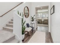 Inviting foyer with staircase, wood floors, and stylish decor, offering a warm welcome at 17825 Gallup St, Broomfield, CO 80023