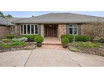 Charming home featuring a brick facade, manicured landscaping, and a welcoming front entrance with a brick walkway at 5145 S Logan Dr, Littleton, CO 80121