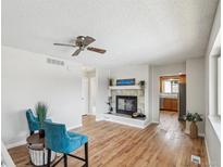 Inviting living room featuring a cozy fireplace, hardwood floors, and a neutral color palette at 574 El Paso Rd, Palmer Lake, CO 80133