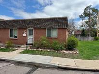 Charming brick home featuring a well-maintained lawn and beautiful landscaping around the property at 769 S Youngfield Ct, Lakewood, CO 80228