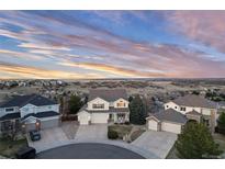 Beautiful sunset aerial view of a two-story home with a three-car garage on a cul-de-sac at 7360 Almandine Ct, Castle Rock, CO 80108