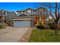 Charming two-story home with stone accents, a spacious driveway, and a manicured lawn at 13818 Krameria St, Thornton, CO 80602