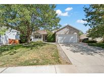 Brick ranch home with attached garage and landscaped lawn at 11480 Moline St, Commerce City, CO 80640