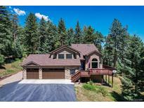 Charming two-story home featuring a three-car garage, stone accents and a welcoming porch at 8171 S Homesteader Dr, Morrison, CO 80465
