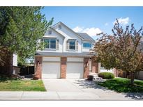 Charming two-story home featuring a three car garage, brick accents, and well-maintained landscaping at 15577 Greenstone Cir, Parker, CO 80134