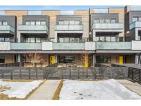 Modern townhome with a yellow front door and a sleek, fenced yard at 2471 Walnut St, Boulder, CO 80302