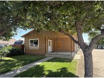 Charming single-story home with a covered front porch and mature trees at 1000 Denver Ave, Fort Lupton, CO 80621