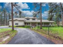 Charming home with a long driveway, fenced yard, and inviting front porch at 18470 Canterbury Dr, Monument, CO 80132