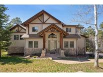 Inviting two-story home featuring a stone facade and a covered front entrance with exposed timber beams at 23 Hess Ave, Golden, CO 80401