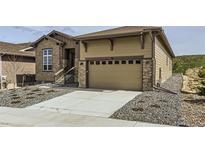 Charming single-Gathering home with a two-car garage, stone accents, and landscaped front yard at 34 Leafy Aster Ln, Castle Rock, CO 80104