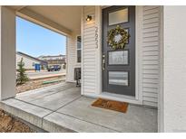Charming home entrance with a wreath on the front door and covered porch at 2653 W 69Th Dr, Denver, CO 80221