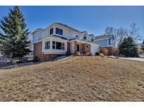 A charming two-story home with a brick and white exterior and a well-maintained front yard at 69 Dawn Heath Cir, Littleton, CO 80127