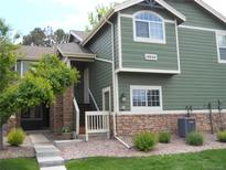 Charming two-story home with stone accents, landscaped yard, and well-maintained green exterior at 19692 E Mann Creek Dr # D, Parker, CO 80134