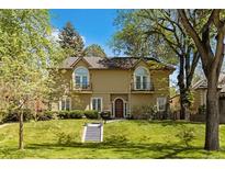 Charming two-story home with a manicured lawn and beautiful architectural details at 1160 Monaco Pkwy, Denver, CO 80220