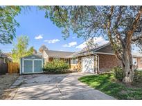 Charming single-story brick home with a well-maintained lawn, detached garage, and mature trees at 5661 E Amherst Ave, Denver, CO 80222