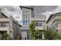 Modern gray two-story home with multi-pane windows, balcony, and manicured landscaping at 6058 Beeler Ct, Denver, CO 80238