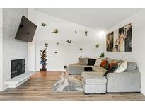 Bright living room features a vaulted ceiling, a fireplace with TV, and a large sectional sofa at 6495 E Happy Canyon Rd # 62, Denver, CO 80237
